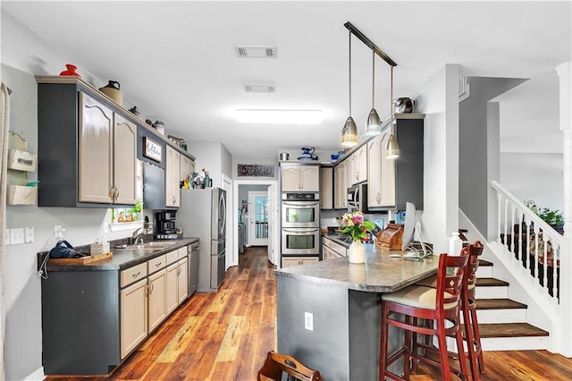 8255A Dixon Rd, Bay Minette, AL 36507 - kitchen featuring a peninsula, appliances with stainless steel finishes, a sink, dark countertops, and a kitchen bar