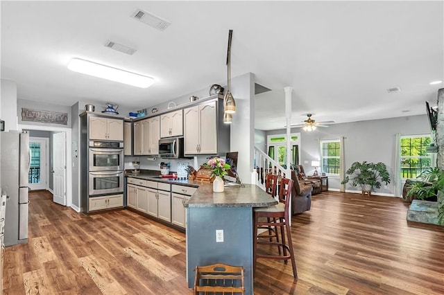 8255A Dixon Rd, Bay Minette, AL 36507 - kitchen with stainless steel appliances, a peninsula, dark countertops, open floor plan, and a breakfast bar