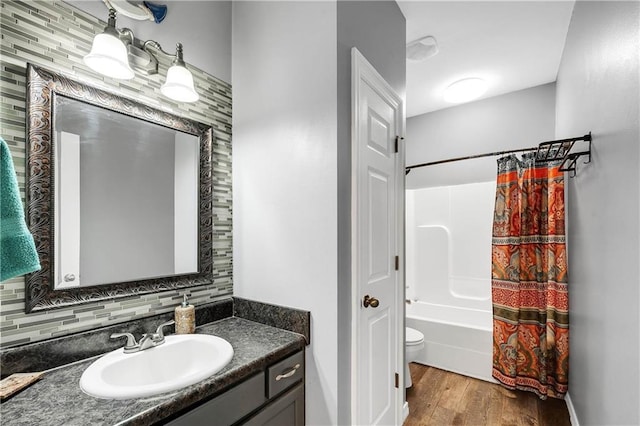 8255A Dixon Rd, Bay Minette, AL 36507 - bathroom with wood finished floors, shower / bath combo with shower curtain, vanity, decorative backsplash, and toilet