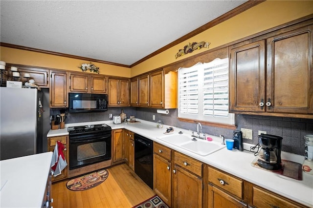 112 Broadmoor Dr, Daphne, AL 36526 - kitchen featuring black appliances, ornamental molding, light countertops, tasteful backsplash, and brown cabinetry