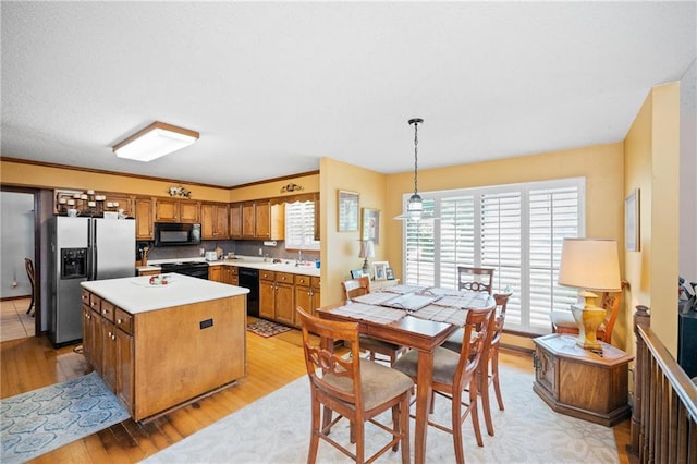 112 Broadmoor Dr, Daphne, AL 36526 - kitchen featuring black appliances, brown cabinetry, light wood-style floors, and a center island