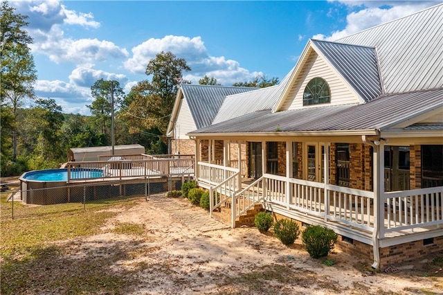 9075 Hamm Cir, Wilmer, AL 36587 - view of property exterior featuring metal roof, an outdoor pool, and a wooden deck