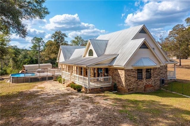 9075 Hamm Cir, Wilmer, AL 36587 - back of property featuring cooling unit, metal roof, a lawn, an outdoor pool, and a porch
