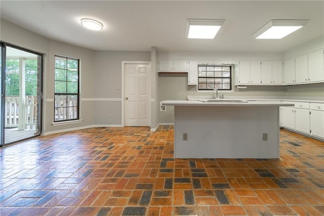 kitchen featuring a center island, white cabinetry, and sink