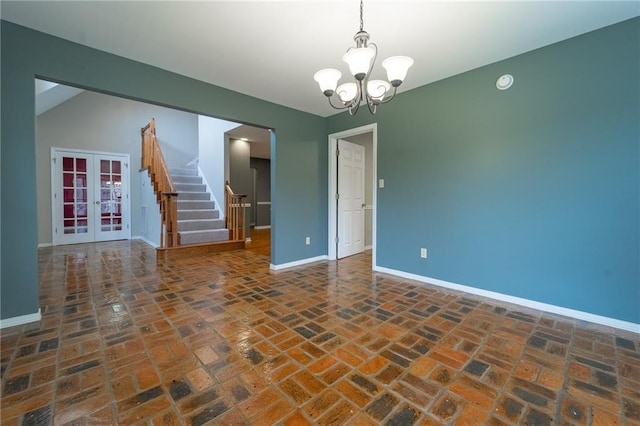 9075 Hamm Cir, Wilmer, AL 36587 - empty room with brick floors, baseboards, a chandelier, stairs, and french doors