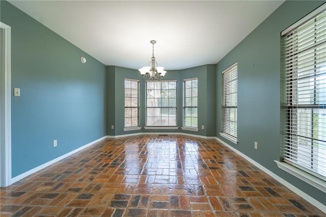9075 Hamm Cir, Wilmer, AL 36587 - empty room featuring baseboards, a chandelier, and brick flooring