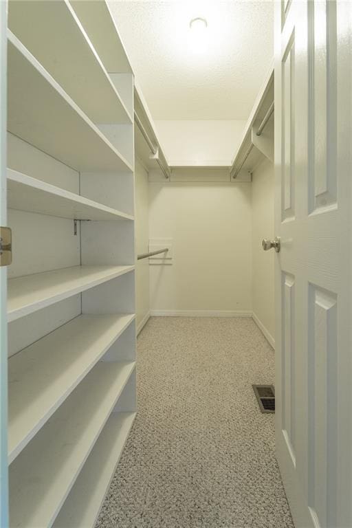 walk in closet with carpet flooring