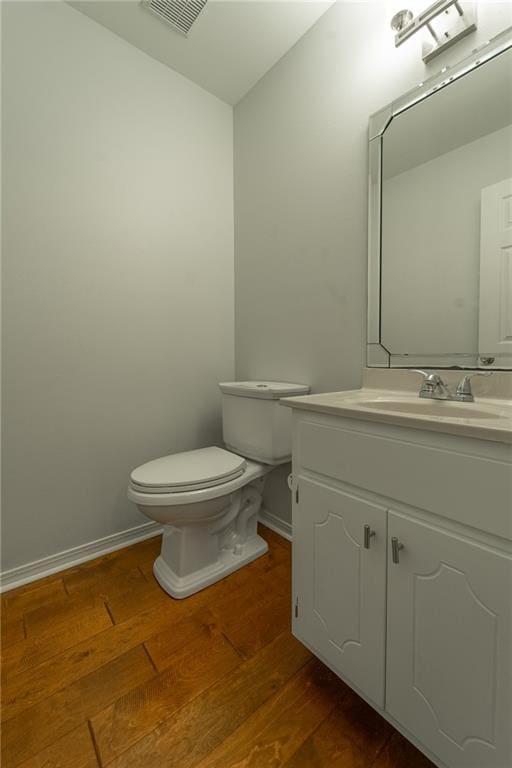 bathroom with vanity, toilet, and wood-type flooring