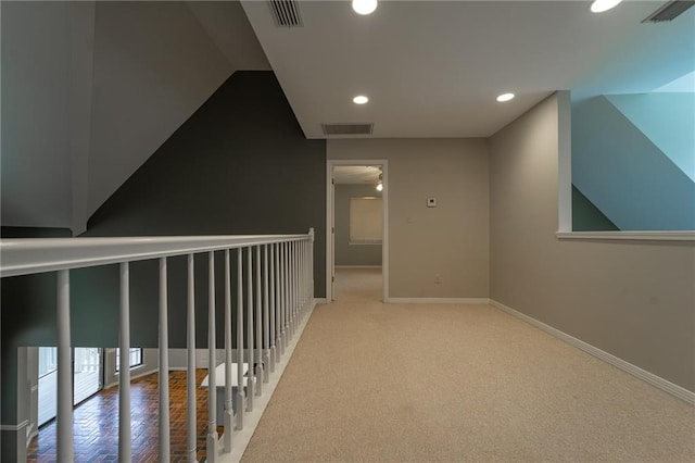 corridor featuring lofted ceiling and carpet floors