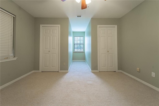 unfurnished bedroom with ceiling fan and light colored carpet