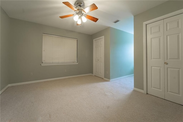 unfurnished bedroom featuring light carpet and ceiling fan