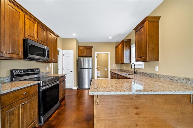 kitchen featuring light stone countertops, sink, a kitchen breakfast bar, kitchen peninsula, and appliances with stainless steel finishes