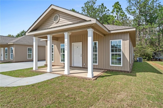 exterior space featuring cooling unit, covered porch, and a front yard