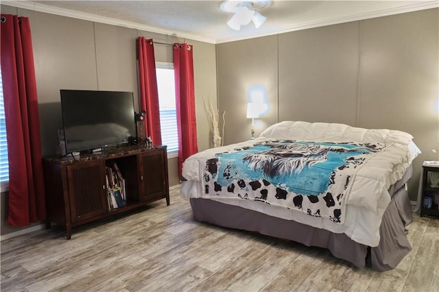 bedroom featuring ornamental molding, ceiling fan, and light wood-type flooring