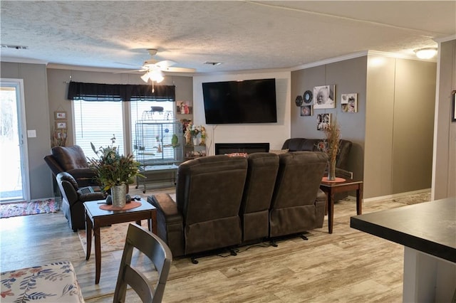 living room featuring light wood-type flooring, ceiling fan, and a wealth of natural light