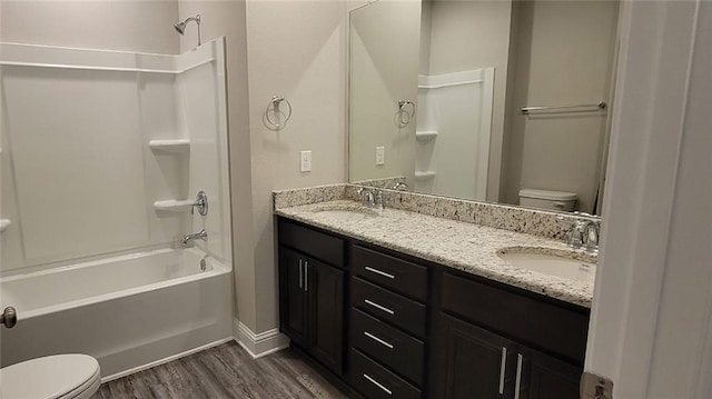 full bathroom with vanity, hardwood / wood-style floors, washtub / shower combination, and toilet