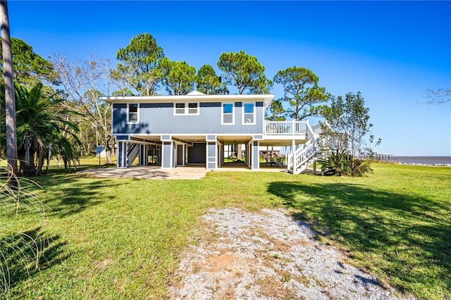 view of front facade with a water view, a front yard, and a carport