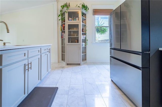 7 Reed Ave N, Mobile, AL 36604 - kitchen with freestanding refrigerator, a sink, crown molding, light marble finish floors, and light countertops