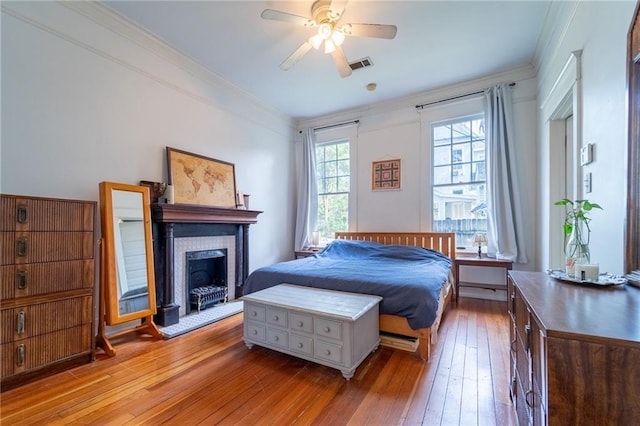 7 Reed Ave N, Mobile, AL 36604 - bedroom featuring wood-type flooring, crown molding, a fireplace, and a ceiling fan