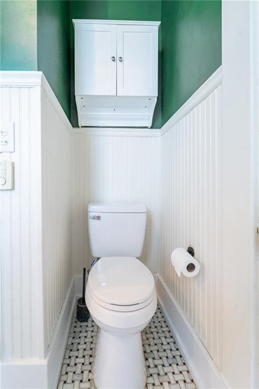 7 Reed Ave N, Mobile, AL 36604 - bathroom with wainscoting, toilet, a decorative wall, and tile patterned floors