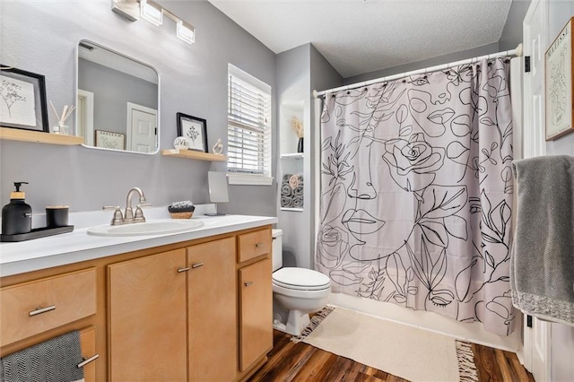 901 La Mothe Pl, Dauphin Island, AL 36528 - bathroom with vanity, wood finished floors, a textured ceiling, toilet, and shower / tub combo with curtain