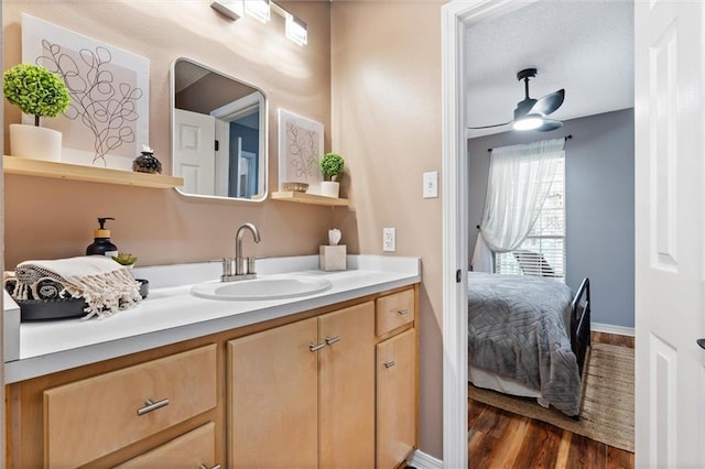 901 La Mothe Pl, Dauphin Island, AL 36528 - bathroom with vanity, wood finished floors, baseboards, a ceiling fan, and ensuite bathroom