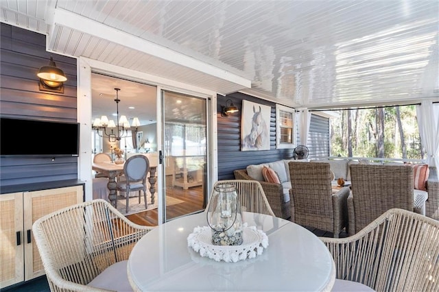 901 La Mothe Pl, Dauphin Island, AL 36528 - sunroom / solarium featuring outdoor dining area, beam ceiling, and a notable chandelier