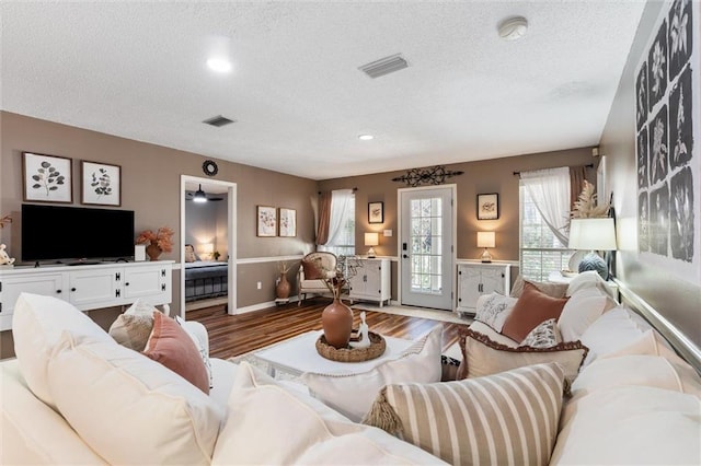 901 La Mothe Pl, Dauphin Island, AL 36528 - living room featuring visible vents, baseboards, a textured ceiling, and wood finished floors