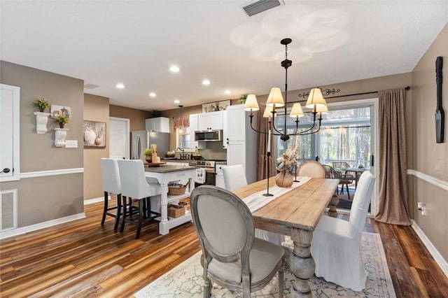 901 La Mothe Pl, Dauphin Island, AL 36528 - dining space featuring an inviting chandelier, wood finished floors, visible vents, and baseboards