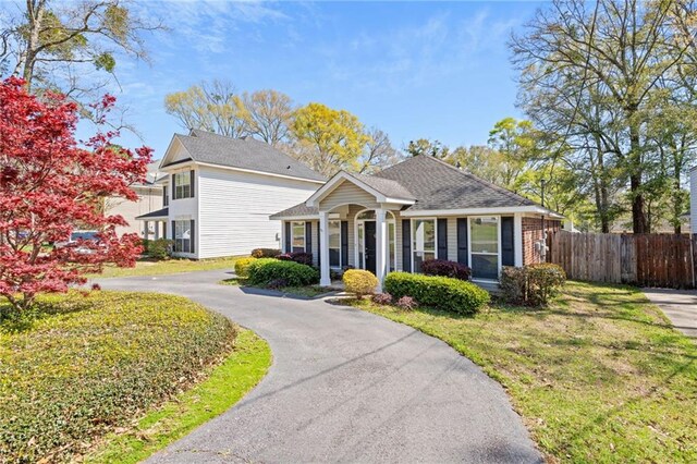 view of front of property featuring a front lawn and fence