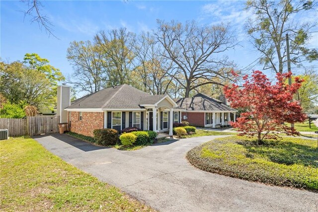 view of front of house with a front lawn, fence, and driveway