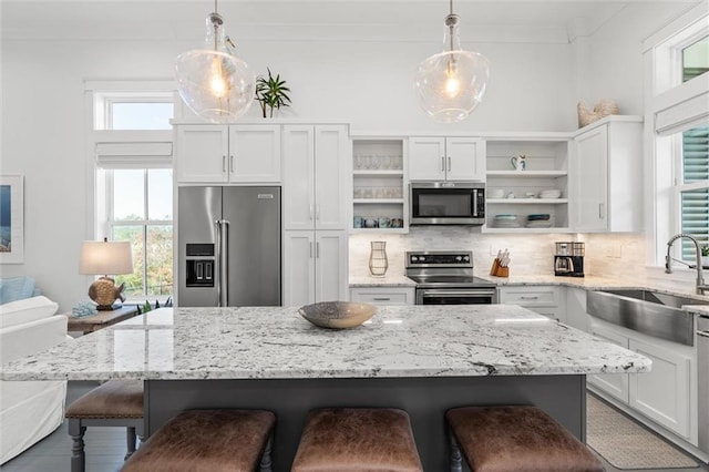 2455 Saltgrass Way, Orange Beach, AL 36561 - kitchen with stainless steel appliances, open shelves, a sink, and plenty of natural light