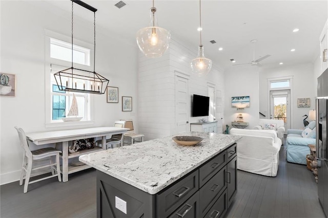 2455 Saltgrass Way, Orange Beach, AL 36561 - kitchen featuring dark wood-type flooring, open floor plan, a center island, light stone countertops, and gray cabinetry