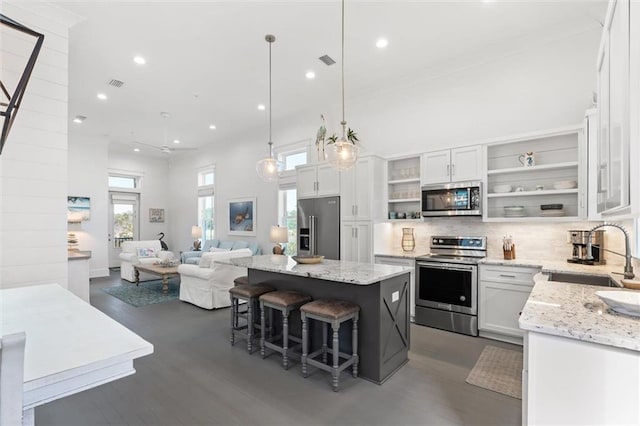 2455 Saltgrass Way, Orange Beach, AL 36561 - kitchen featuring appliances with stainless steel finishes, a sink, open shelves, open floor plan, and white cabinetry