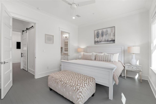 2455 Saltgrass Way, Orange Beach, AL 36561 - bedroom with baseboards, a barn door, ensuite bath, crown molding, and wood finished floors