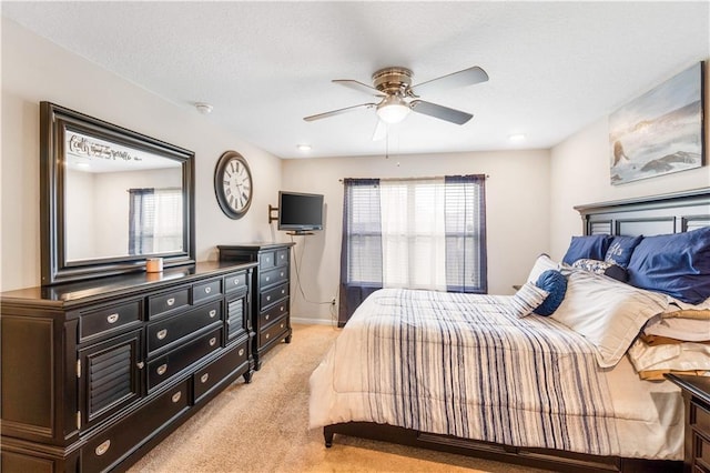 bedroom with ceiling fan and light carpet