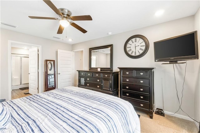 bedroom featuring connected bathroom, light colored carpet, and ceiling fan