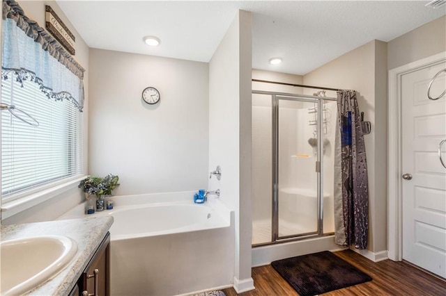 bathroom with shower with separate bathtub, hardwood / wood-style floors, and vanity