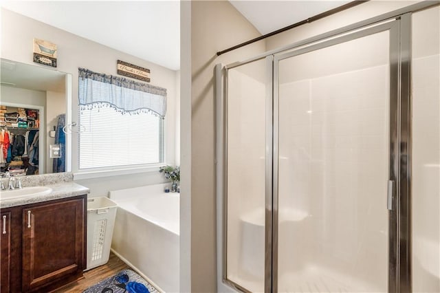 bathroom featuring hardwood / wood-style flooring, shower with separate bathtub, and vanity