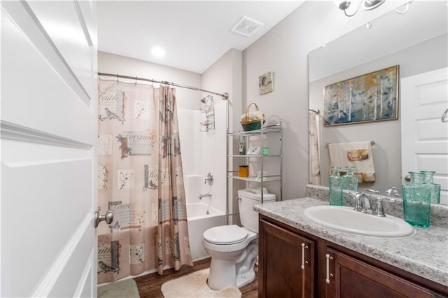 full bathroom featuring hardwood / wood-style flooring, vanity, shower / tub combo with curtain, and toilet