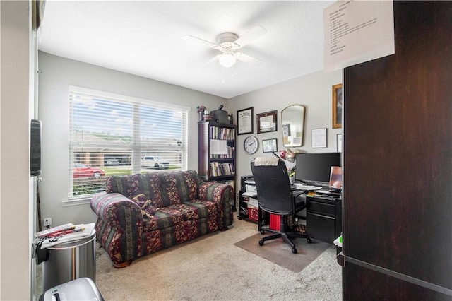 carpeted office space featuring ceiling fan