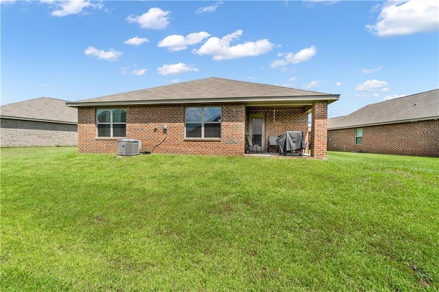 back of house with a yard and central AC