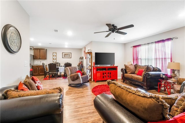 living room with ceiling fan and light hardwood / wood-style flooring