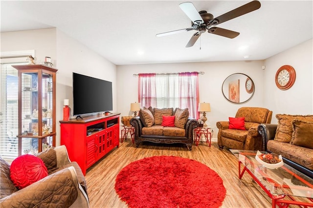 living room with light hardwood / wood-style flooring and ceiling fan