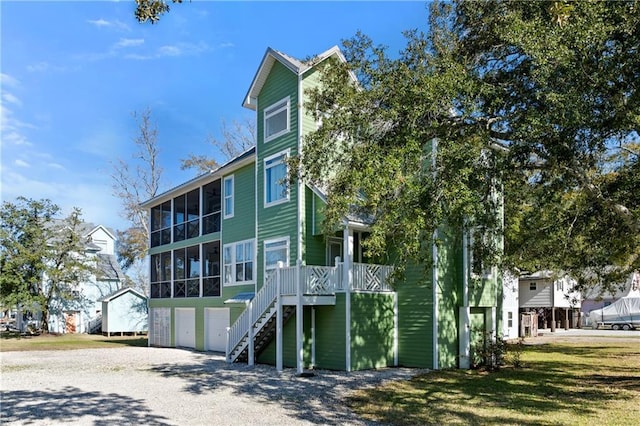 rear view of house with a garage and a sunroom