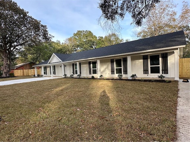 ranch-style house featuring covered porch and a front lawn