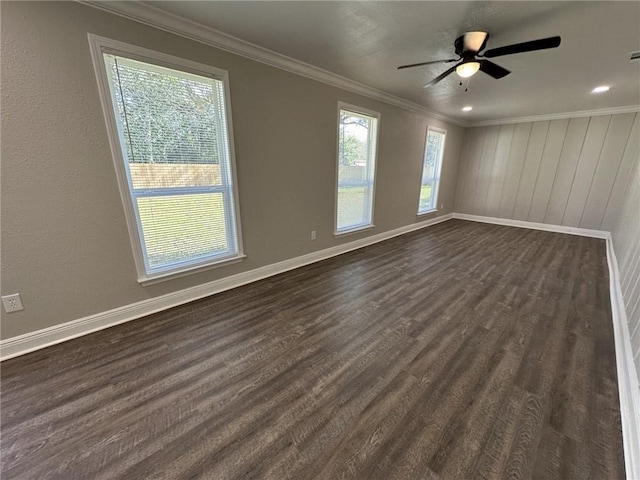 empty room featuring ceiling fan, wood walls, dark hardwood / wood-style floors, and ornamental molding