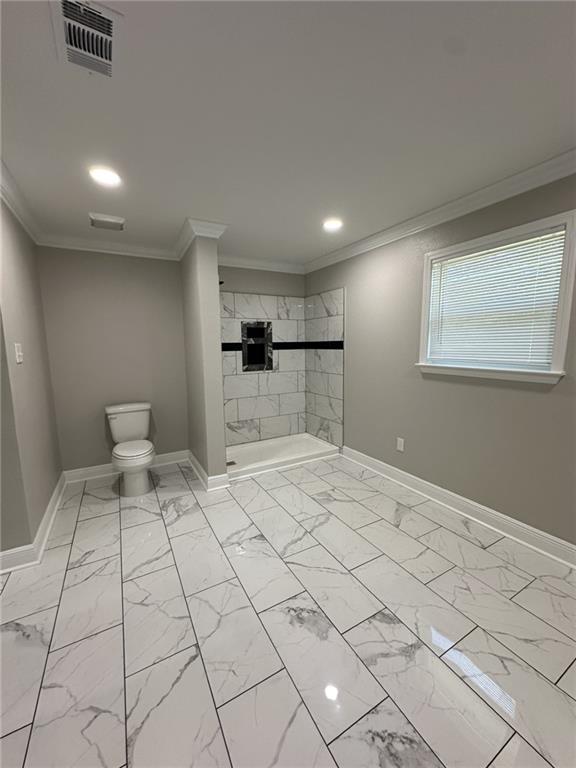 bathroom with a shower, toilet, and ornamental molding