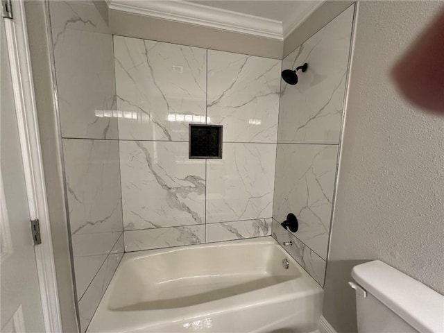 bathroom with crown molding, toilet, and tiled shower / bath