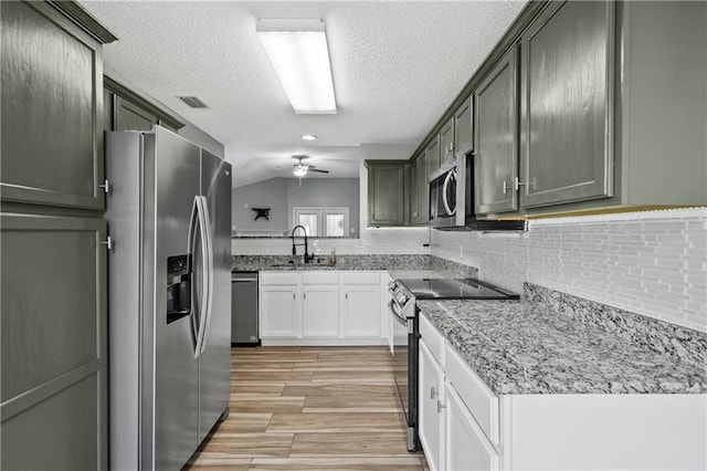 kitchen featuring visible vents, a ceiling fan, a sink, appliances with stainless steel finishes, and light wood finished floors